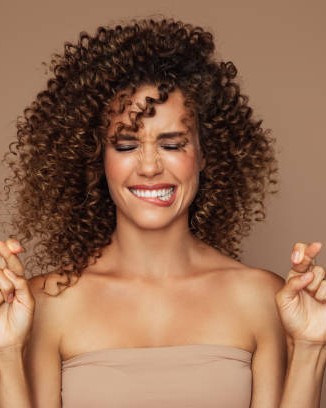 Boucles brunes volumineuses, sourire