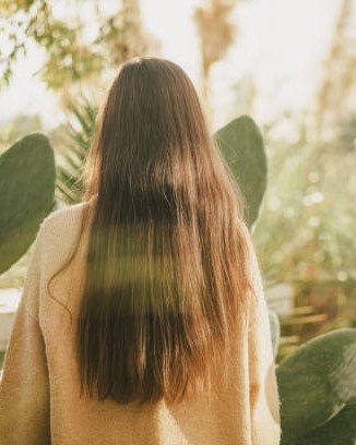 Longs cheveux bruns vus de dos dans un jardin